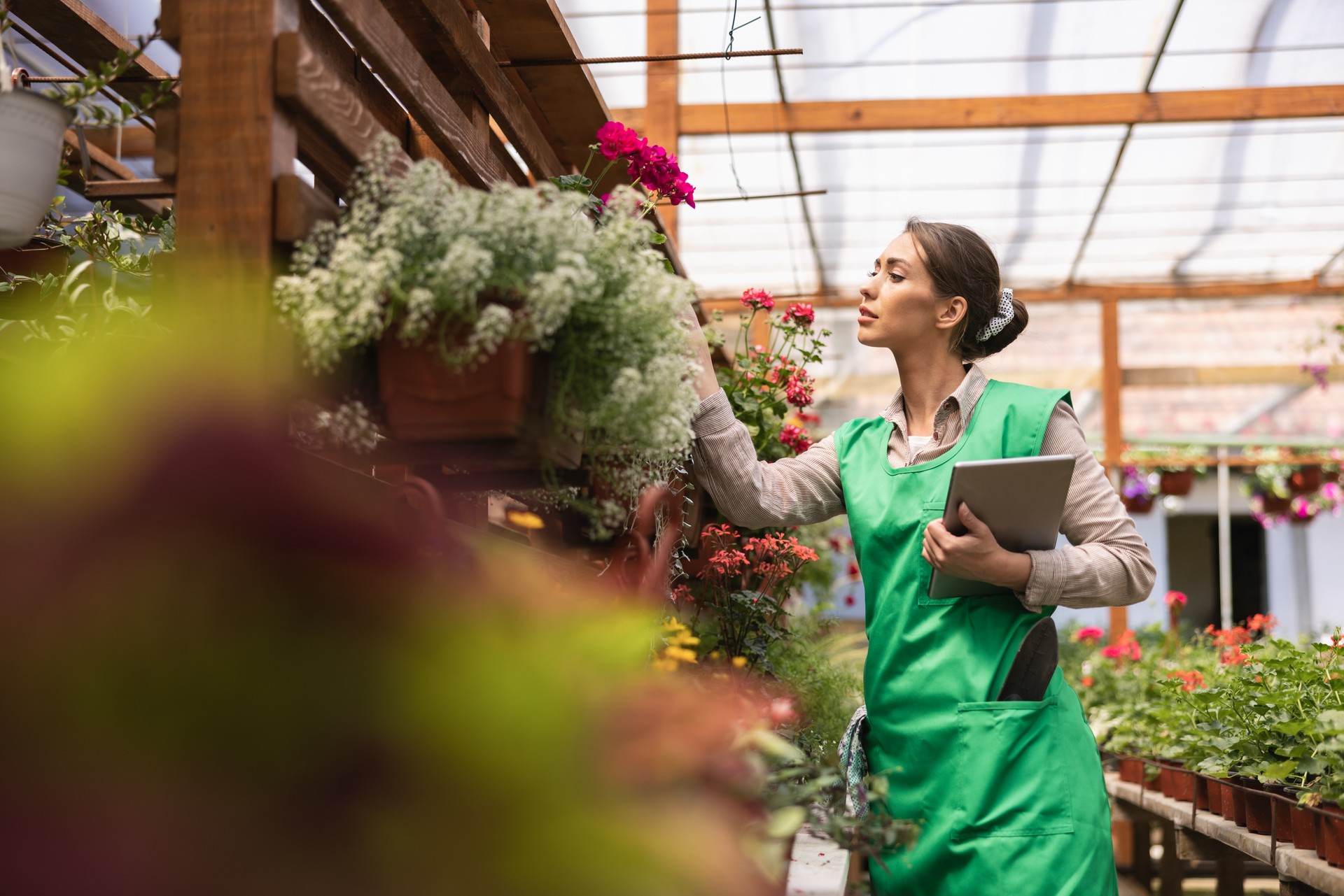 Florist Woman With Digital Tablet Care About Flowers In Garden Center